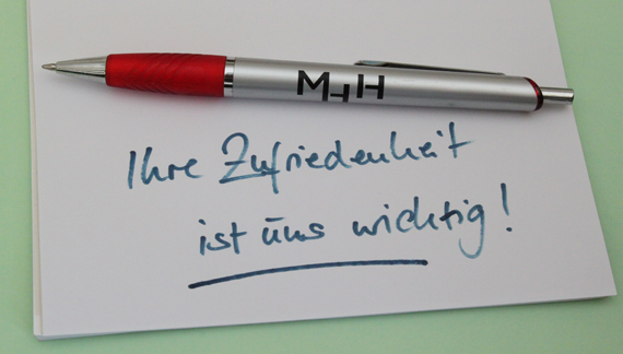 Notitzzettel mit Stift und Aufschrift Ihre Zufriedenheit ist uns wichtig