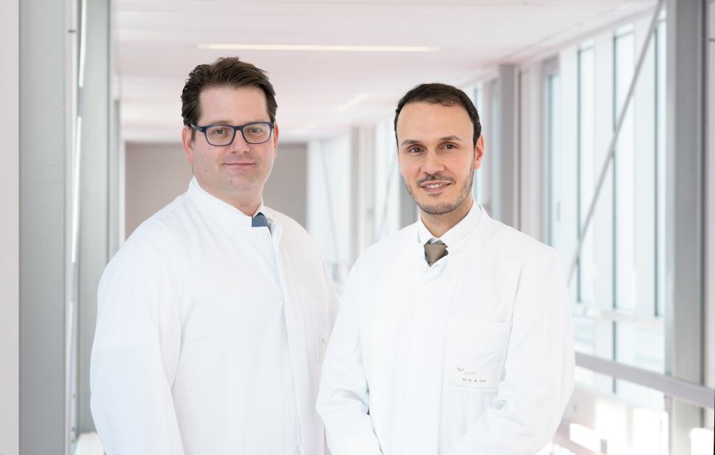 Copyright: Ilka Kosmalski/ MHH Der Zentrumskoordinator PD Dr. med. Philipp Ivanyi und der ärztliche Leiter PD Dr. med. Mohamed Omar nebeneinander im weißen Arztkittel.