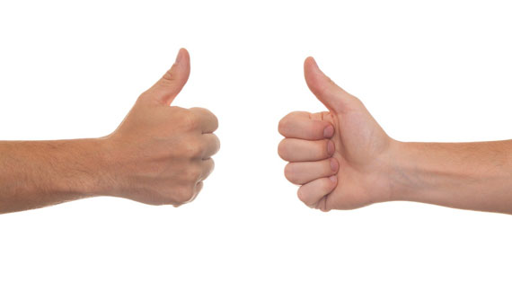 zwei Hände zeigen hochgehaltene Daumen in die Mitte