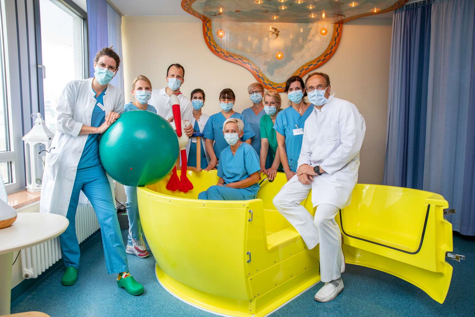 Foto: Karin Kaiser | MHH MHH Geburtshilfeteam mit Coronamasken umstellt eine gelbe Geburtswanne