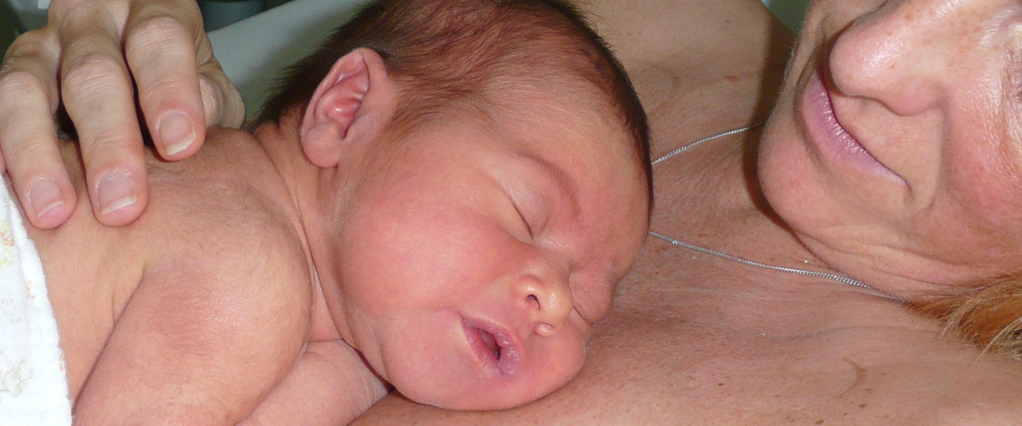 Bonding - Baby liegt im Hautkontakt auf der Mutterbrust