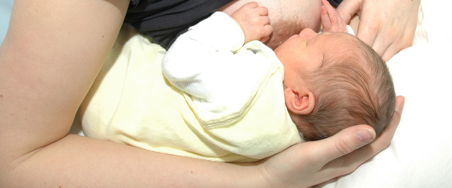 S(c) Frauenklinik|MHH Mutter hält Baby zum Stillen im Arm