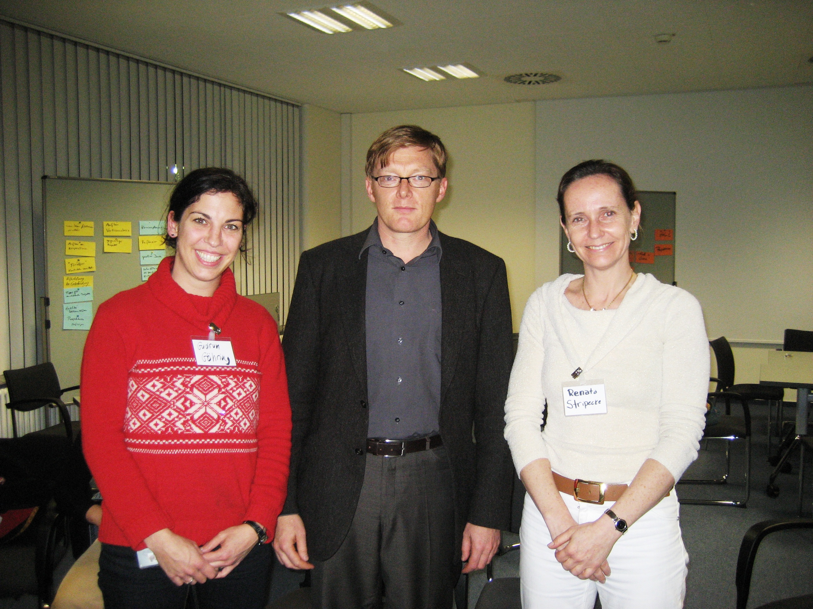 Auf dem Bild stehen die zwei ehemaligen Mentees Professorin Gudrun Göhring und Professorin Renata Stripecke sowie der damaligen Mentor und späteren Präsidenten der MHH Prof. Dr. Christopher Baum (2013-2018). Sie lächeln in die Kamera.