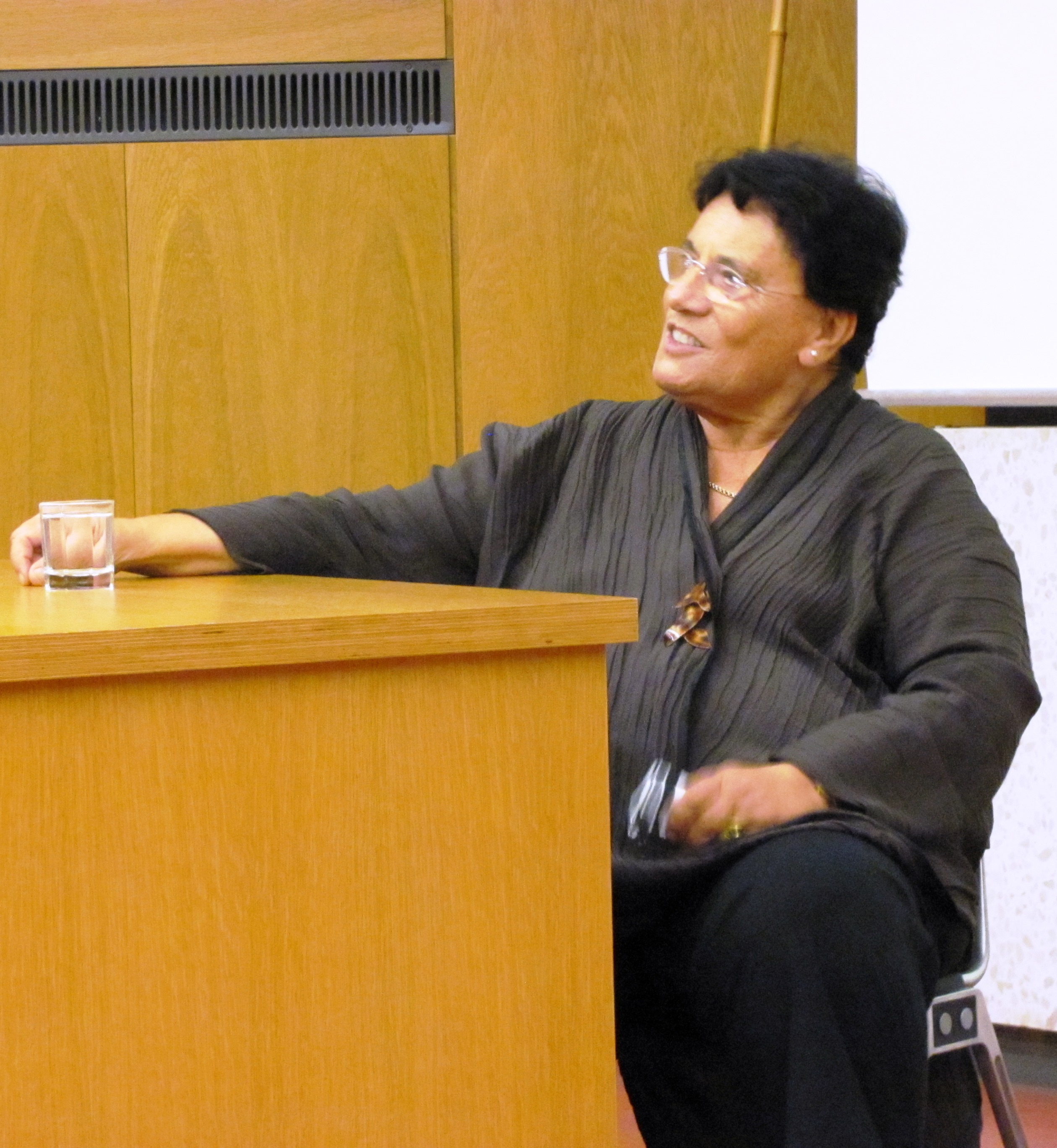 Auf dem Bild sitzt die Namensgeberin Professorin Ina Pichlmayr an einem Tisch im Hörsaal.