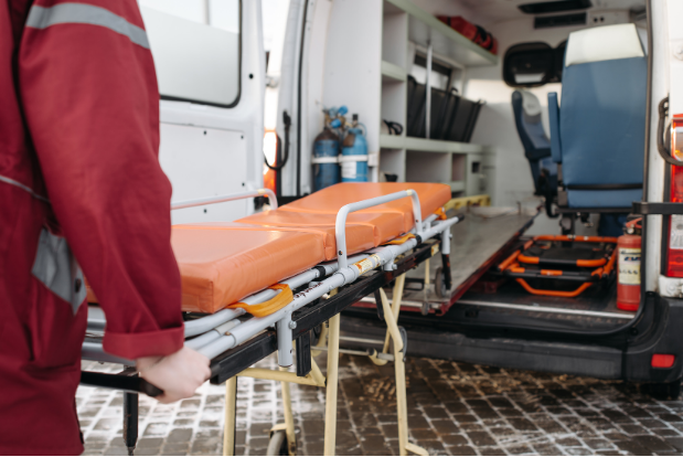 Leere Trage wird von Sanitäter in Krankenwagen geschoben