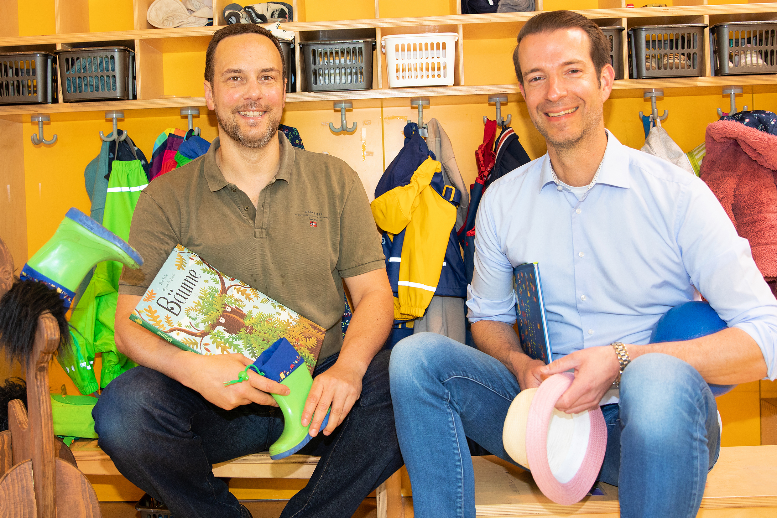 CPD Dr. C. Sturm und Prof. Dr. Dingemann sitzen vor der Garderobe in der Kita