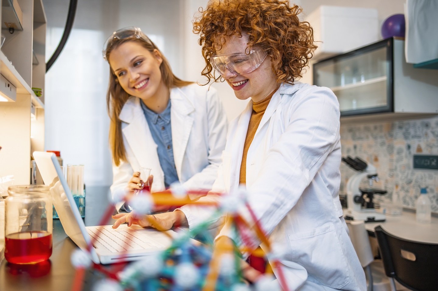 Two female scientists work on a laptop in the lab. Copyright: AdobeStock