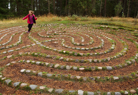 Ein Kind läuft durch ein Steinlabyrinth