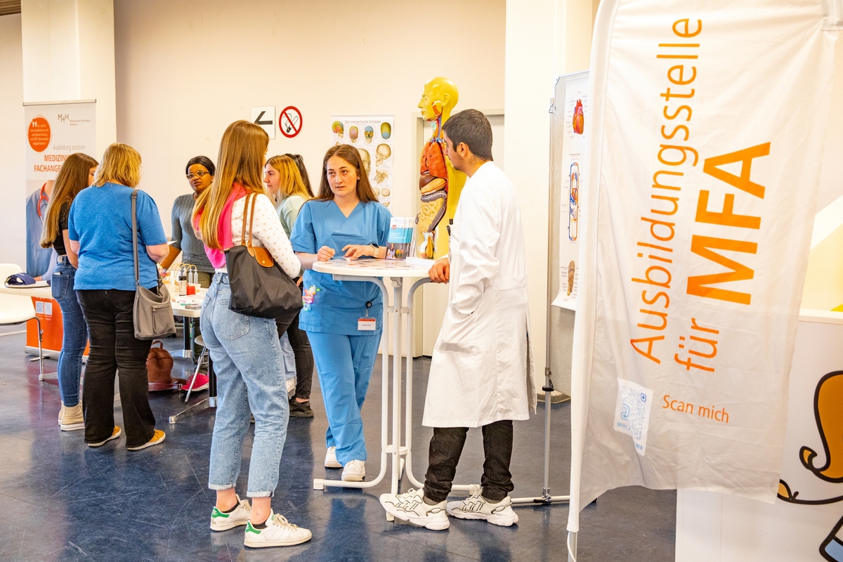 Mehrere Menschen stehen am Stand der MFA-Ausbildung. 