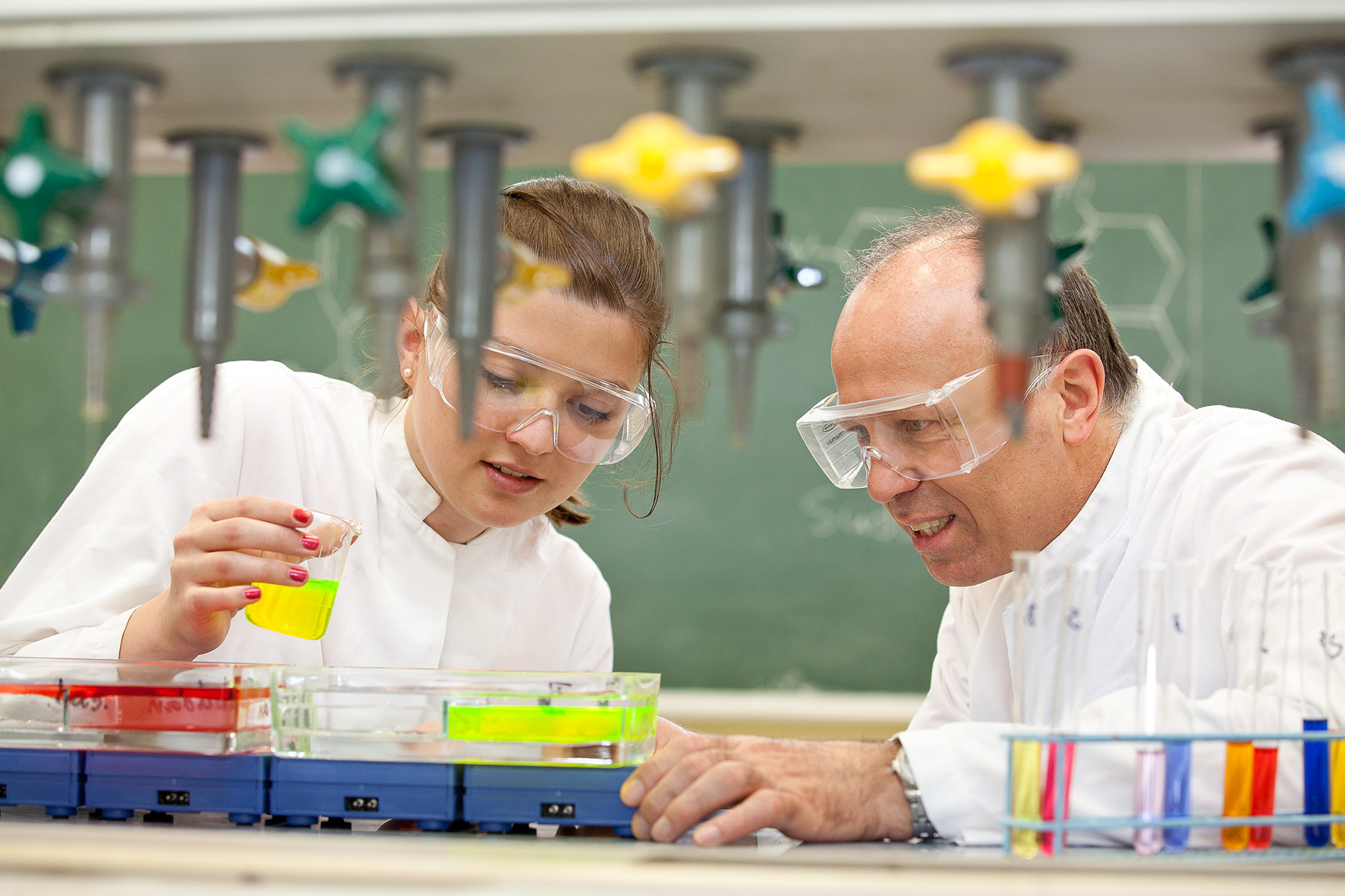 Zwei mit Schutzbrille starten ein Experiment