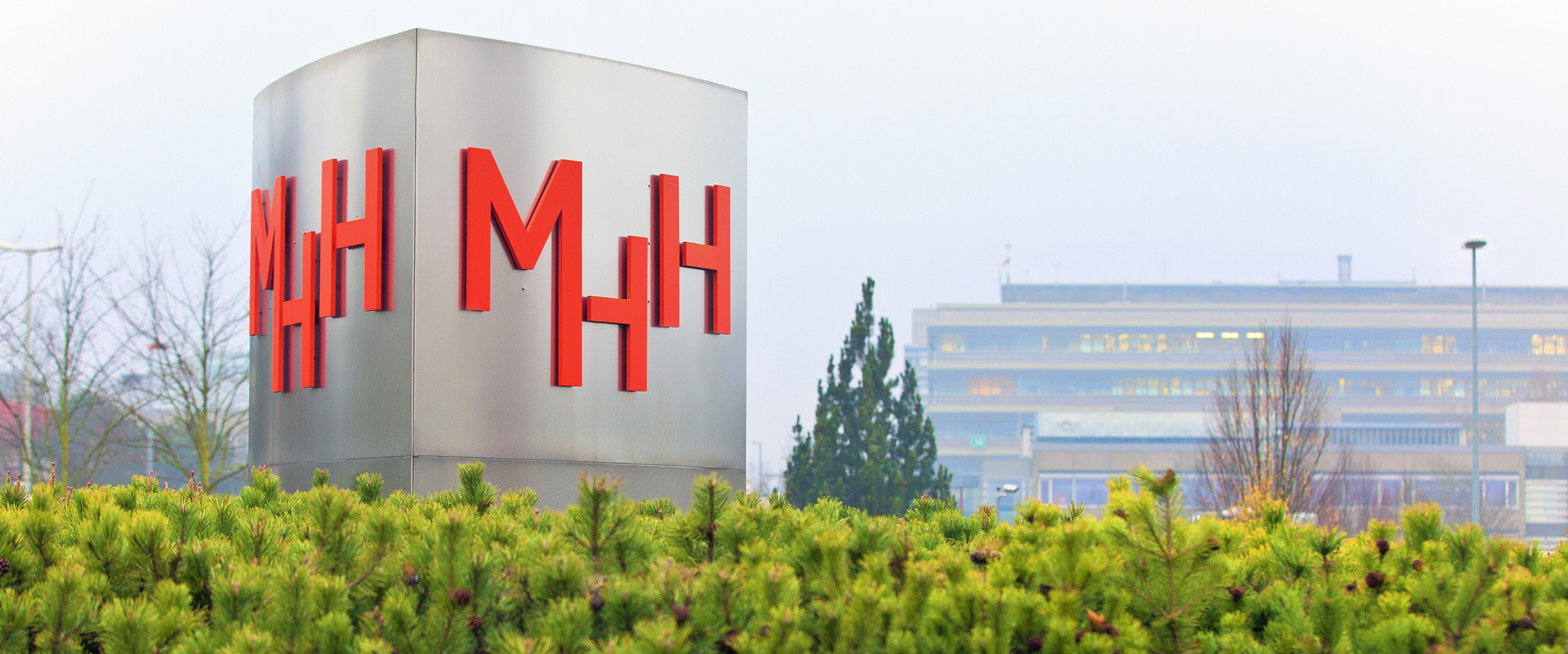 Eine große silberne Stele trägt das Logo der Medizinischen Hochschule Hannover - MHH.