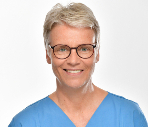 lächelnde Frau mit kruzem weiß/blondem Haar und Brille
