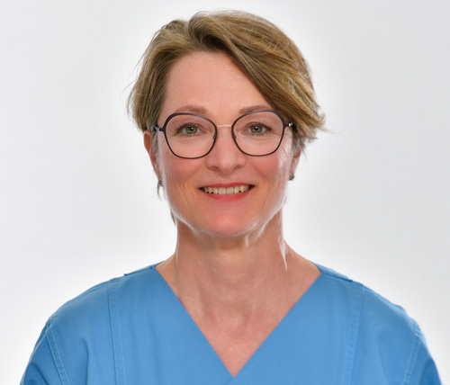 lächelnde Frau mit blonden kurzen Haaren und Brille