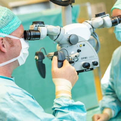 Chirurgen operieren mit Hilfe eines Mikroskops.