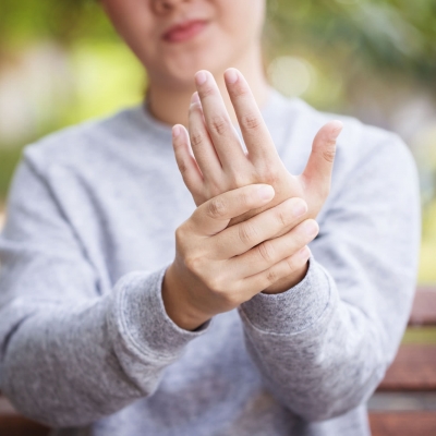 Frau hält mit der rechten Hand die linke Hand in die Kamera