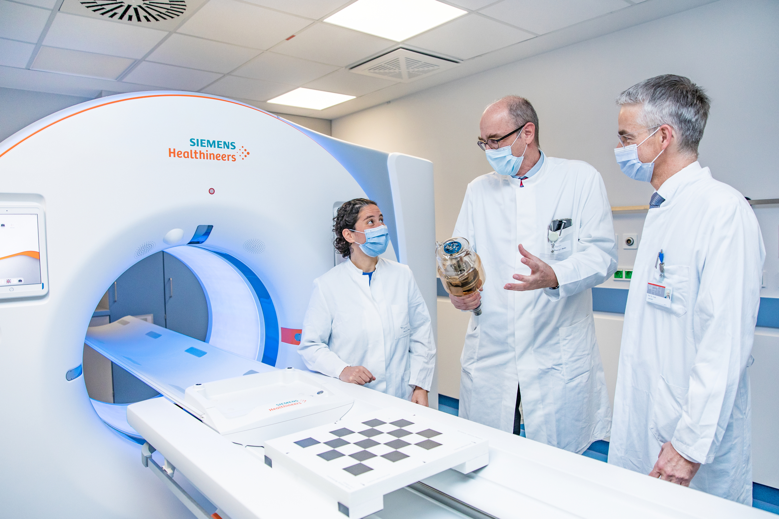 Professorin Dr. Kristina Imeen Ringe, Professor Wacker und Professor Lammert stehen rechts neben dem neuen CT-Gerät. 