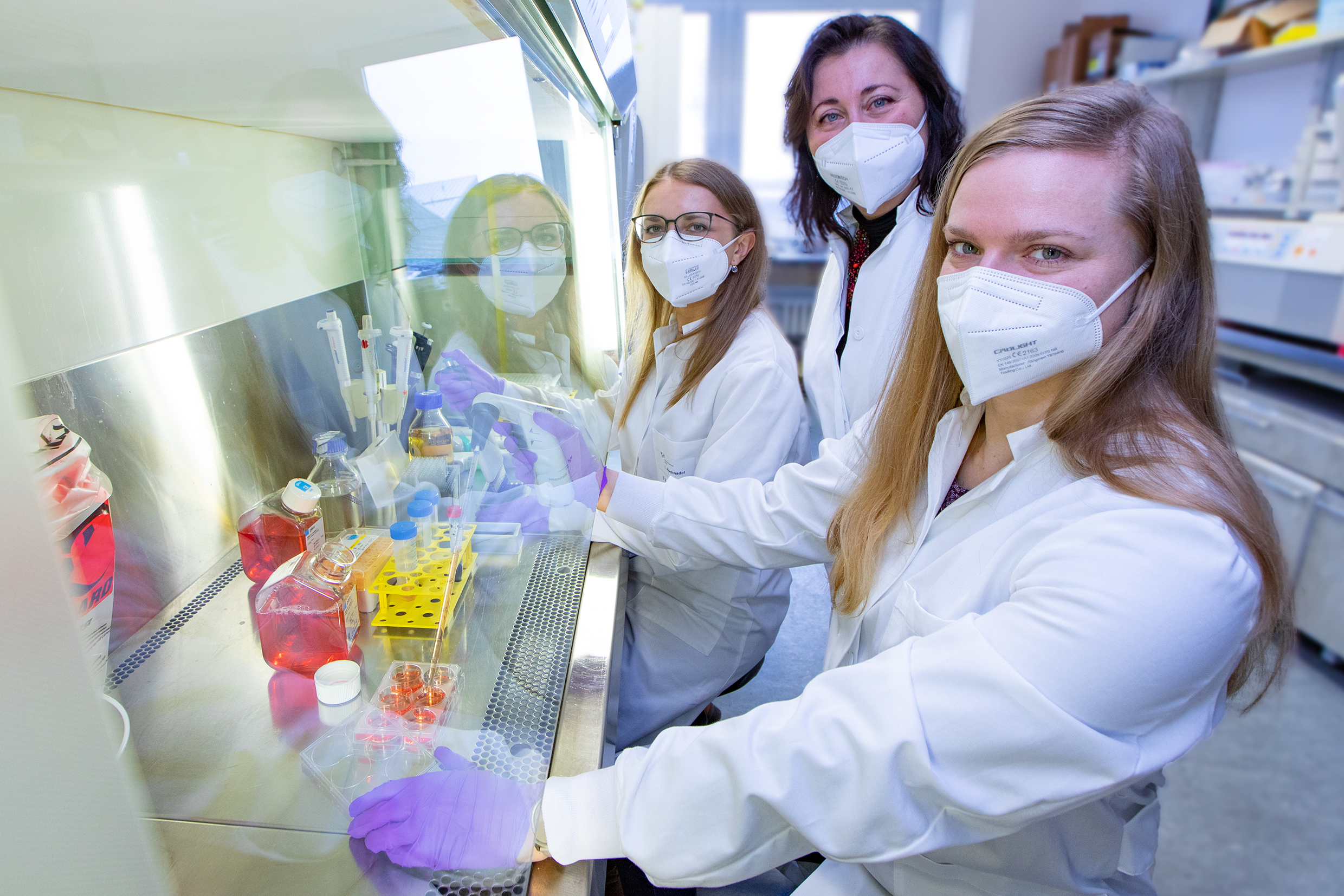 Die Wissenschaftlerinnen Inga Hochnadel, Dr. Tetyana Yevsa und Dr. Lisa Hönicke stehen an einem Arbeitsplatz im Labor.