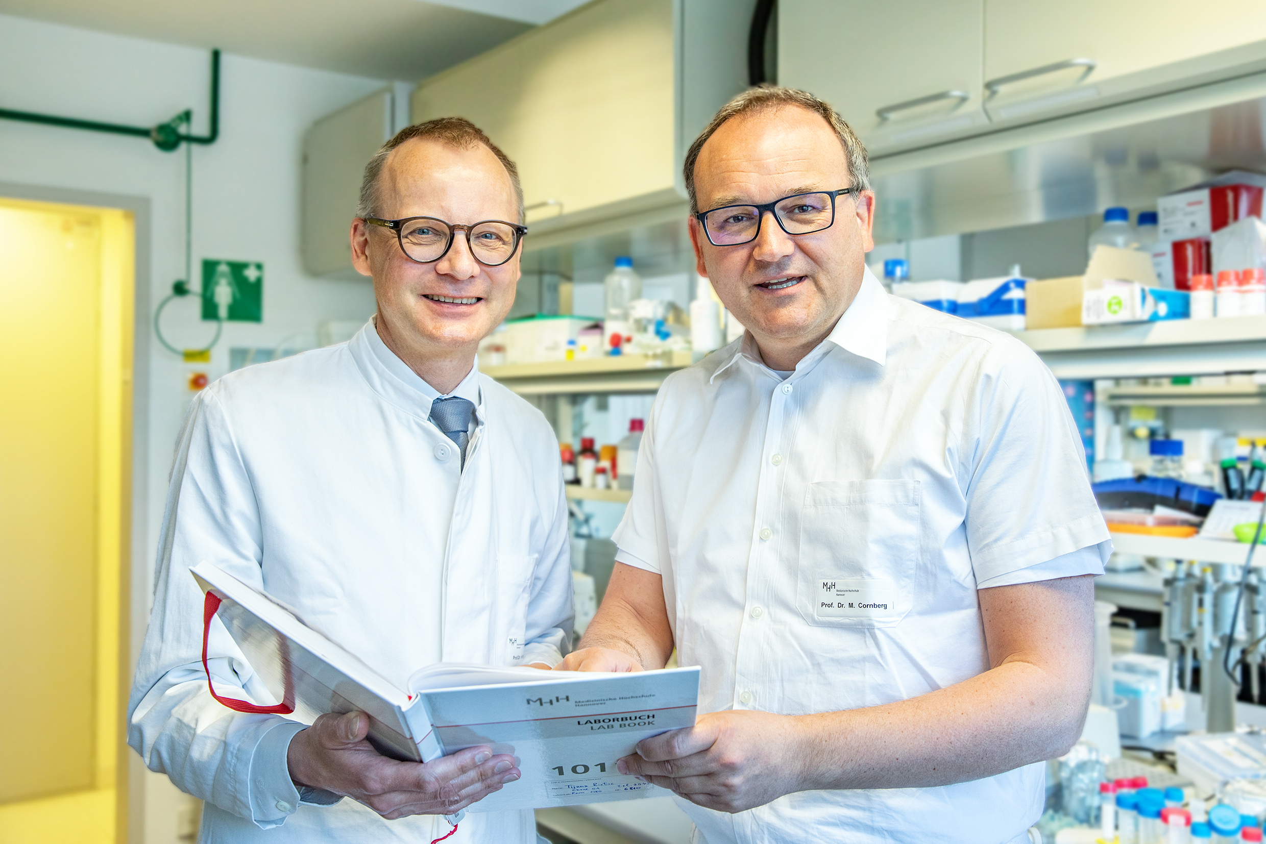 Professor Dr Heiner Wedemeyer and Professor Dr Markus Cornberg stand in a laboratory at the MHH Clinic for Gastroenterology