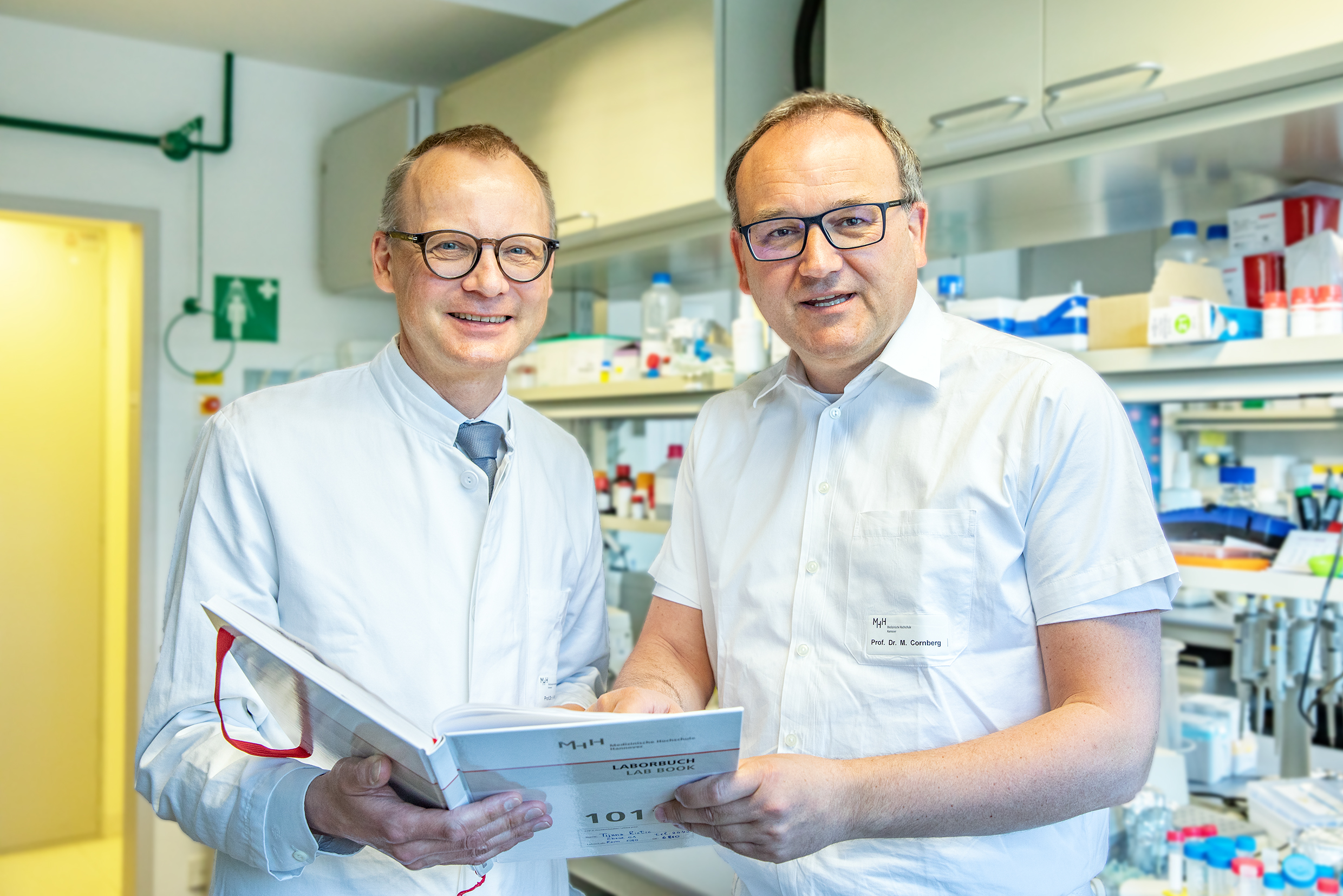 Copyright: Karin Kaiser / MHH Professor Dr. Heiner Wedemeyer und Professor Dr. Markus Cornberg stehen in einem Labor der MHH-Klinik für Gastroenterologie