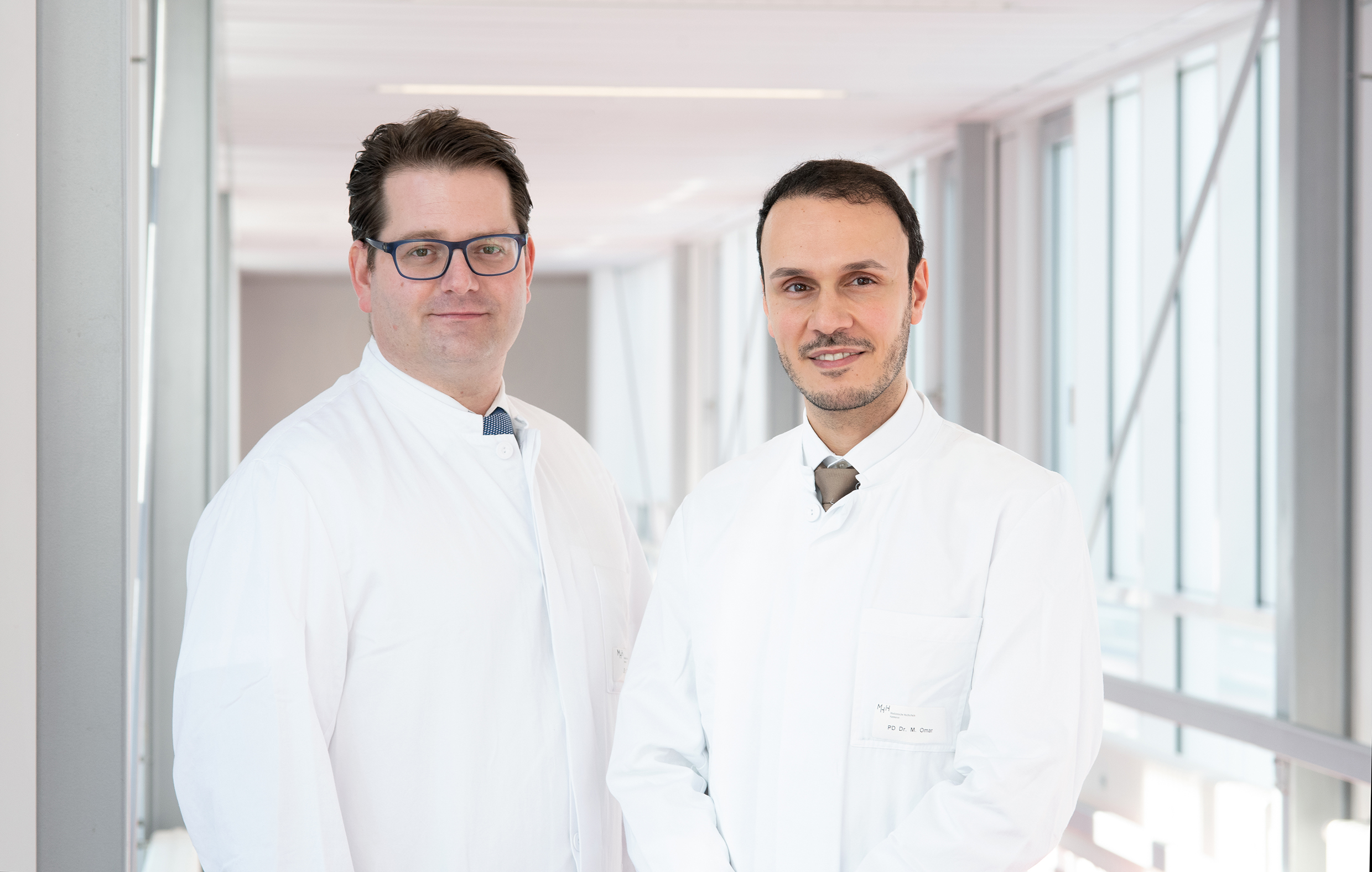 PD Dr. Philipp Ivanyi und Prof. Dr. Mohamed Omar stehen in einem Flur der Medizinischen Hochschule Hannover.