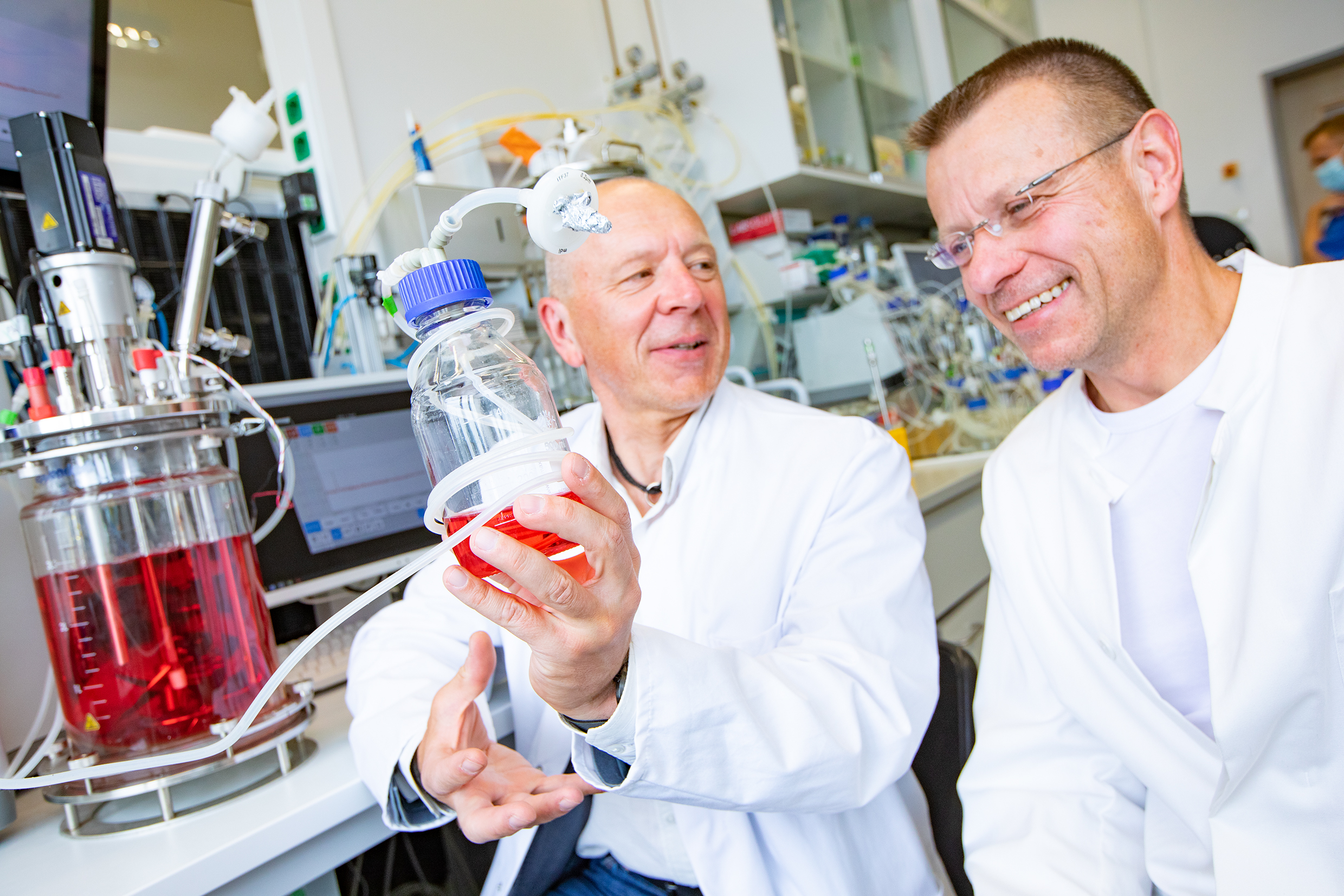 Dr. Robert Zweigerdt und Professor Dr. Ulrich Martin sitzen in einem Bioreaktorlabor der MHH