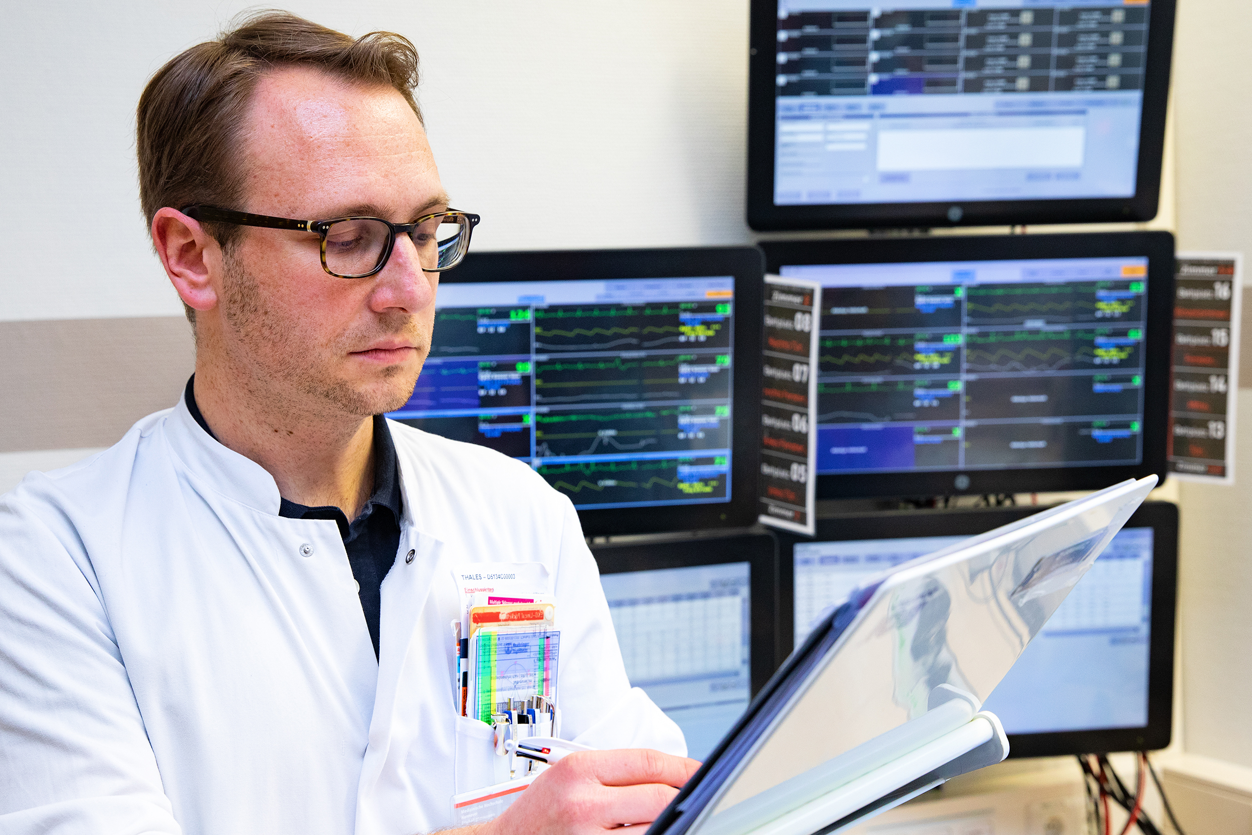 Copyright: Karin Kaiser / MHH PD Dr. Gerrit Große hält eine Akte in der Hand und schaut sich klinische Daten von Schlaganfall-Patientinnen und -Patienten auf der Stroke Unit an.