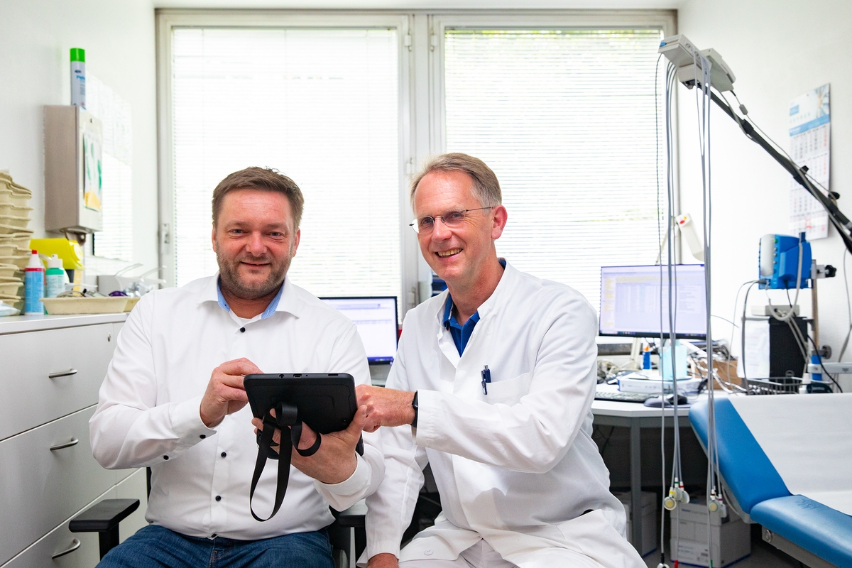 Dr. Matthias Gietzelt and Professor Bavendiek sit next to each other in a cardiology examination room.