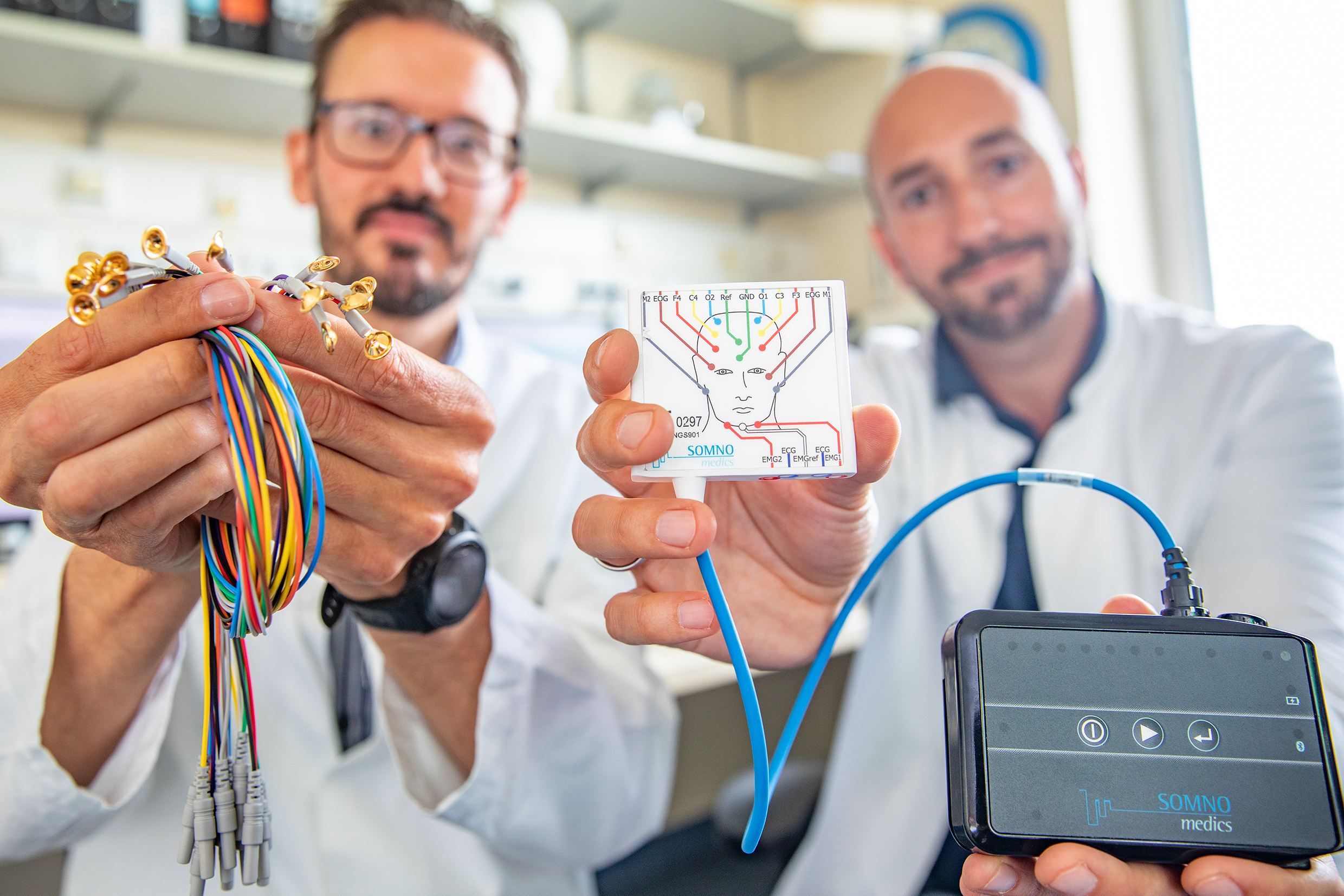 MHH neurologists Dr. Matthias Höllerhage (left) and Dr. Martin Klietz hold a device for mobile video sleep monitoring.