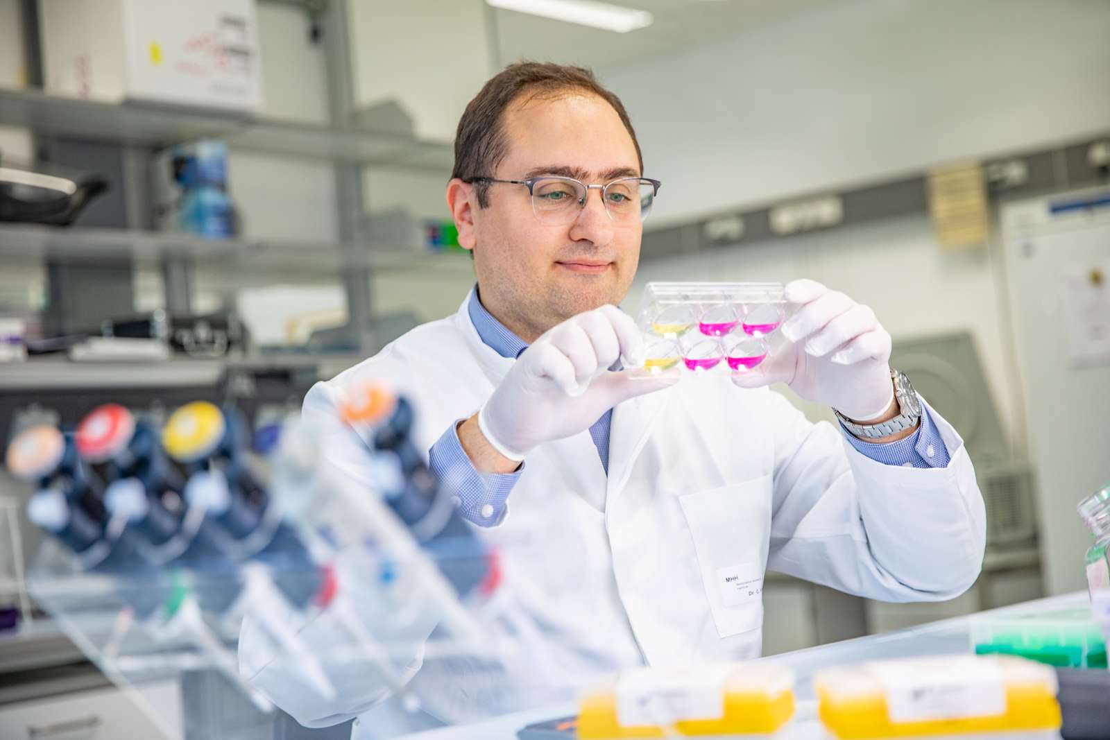 Dr Georgios Amanakis stands in a laboratory of the Clinic for Cardiology and Angiology and holds a cell culture plate in his hands.