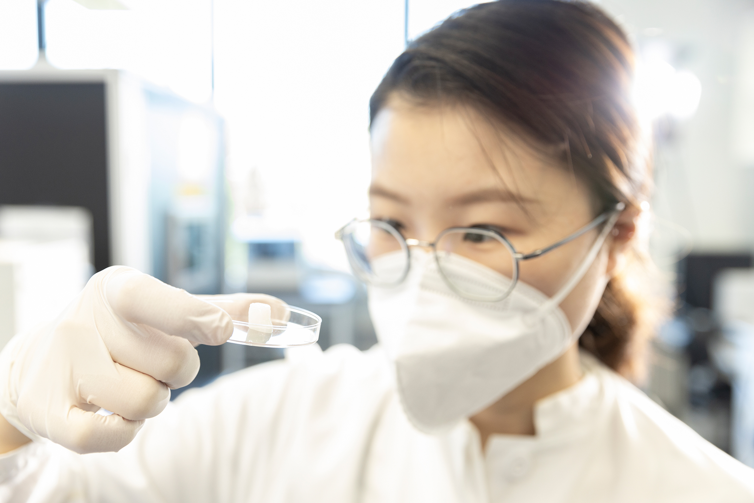 Copyright: Desktop Health Hörforscherin Yanjing Luo hält das Gehörgangsimplantat in einer kleinen Schale