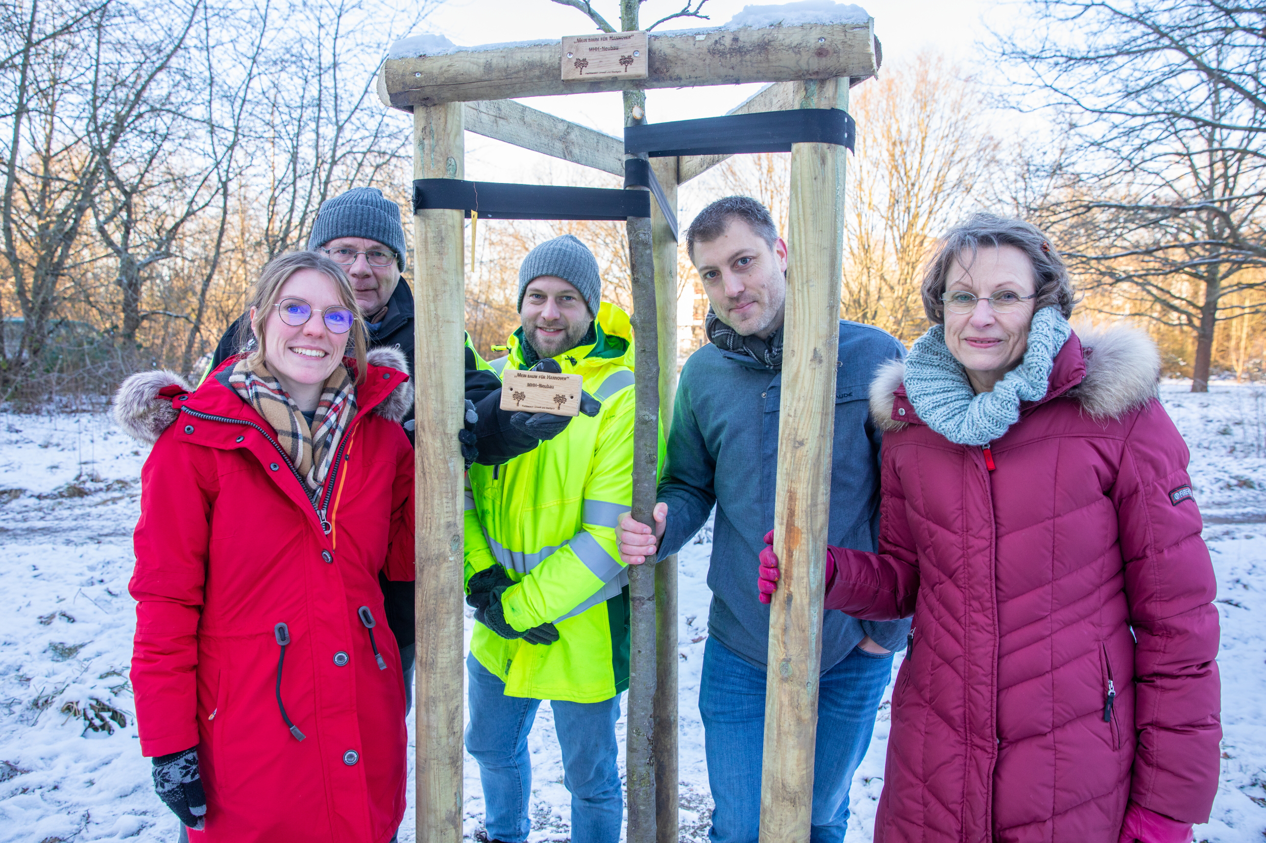 Manuel Kornmayer, Bereichsleitung öffentliche Grünflächen, MHH-Vizepräsidentin Martina Saurin, Eva Hoffmeister, stellvertretende Sachgebietsleitung Baum und Flächenschutz, Tim Neuberger, Sonderaufgaben Werkhof 6 und Holger Severloh, stellvertretender Werkhofleiter 6 (von links) pflanzen einen Apfelbaum.