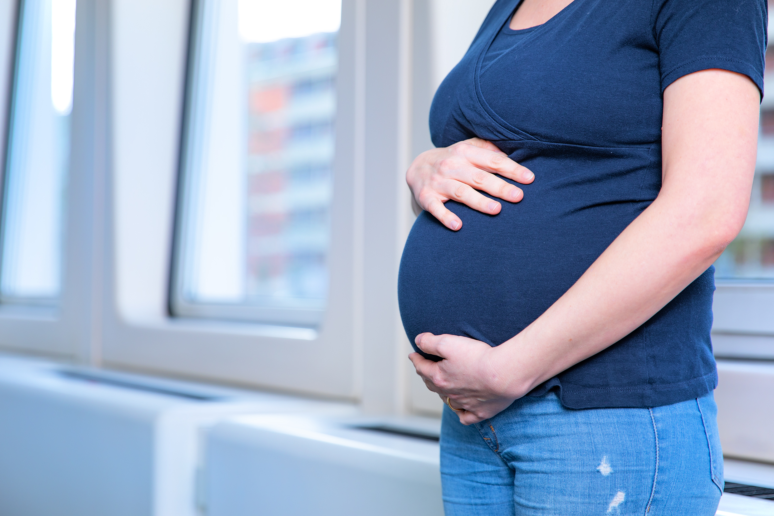 A pregnant woman embraces her belly