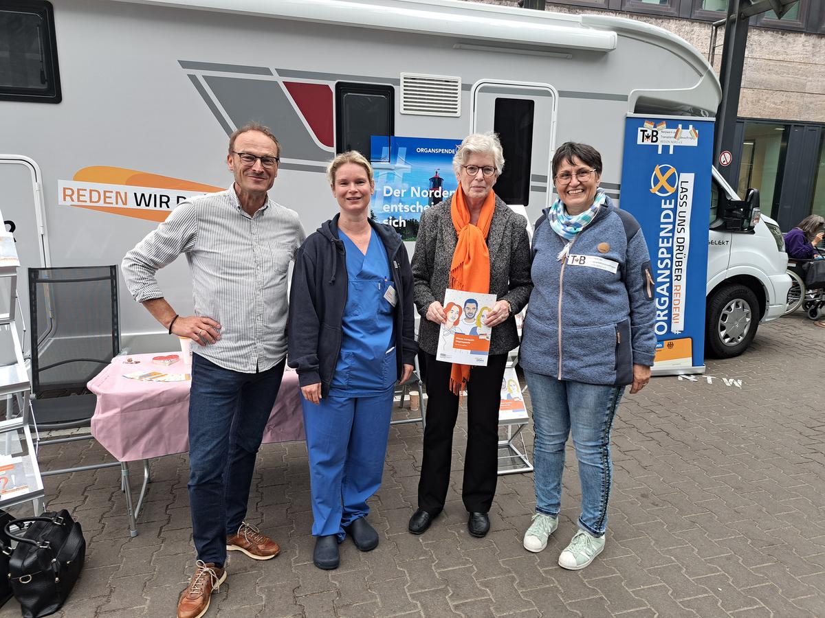 Elke Wiethake vom Klinikum Braunschweig mit einer Patientin, Nicole Drewes vom Klinikum Lüneburg und Dr. Frank Logemann von der MHH stehen vor einem der Wohnmobile, die auf Tour gehen.