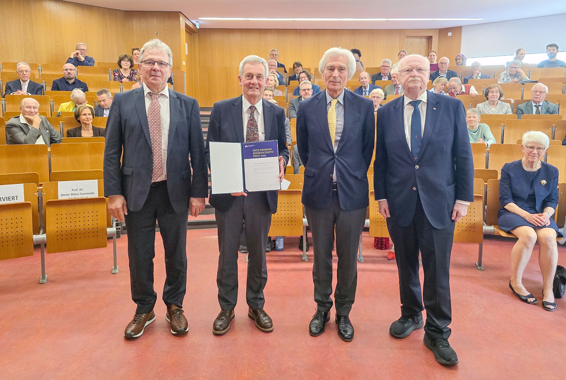 Professor Förster, Professor Schulz, Matthias Fontaine und Professor Manns stehen im Hörsaal H der MHH für eine Foto nebeneinander (von links).
