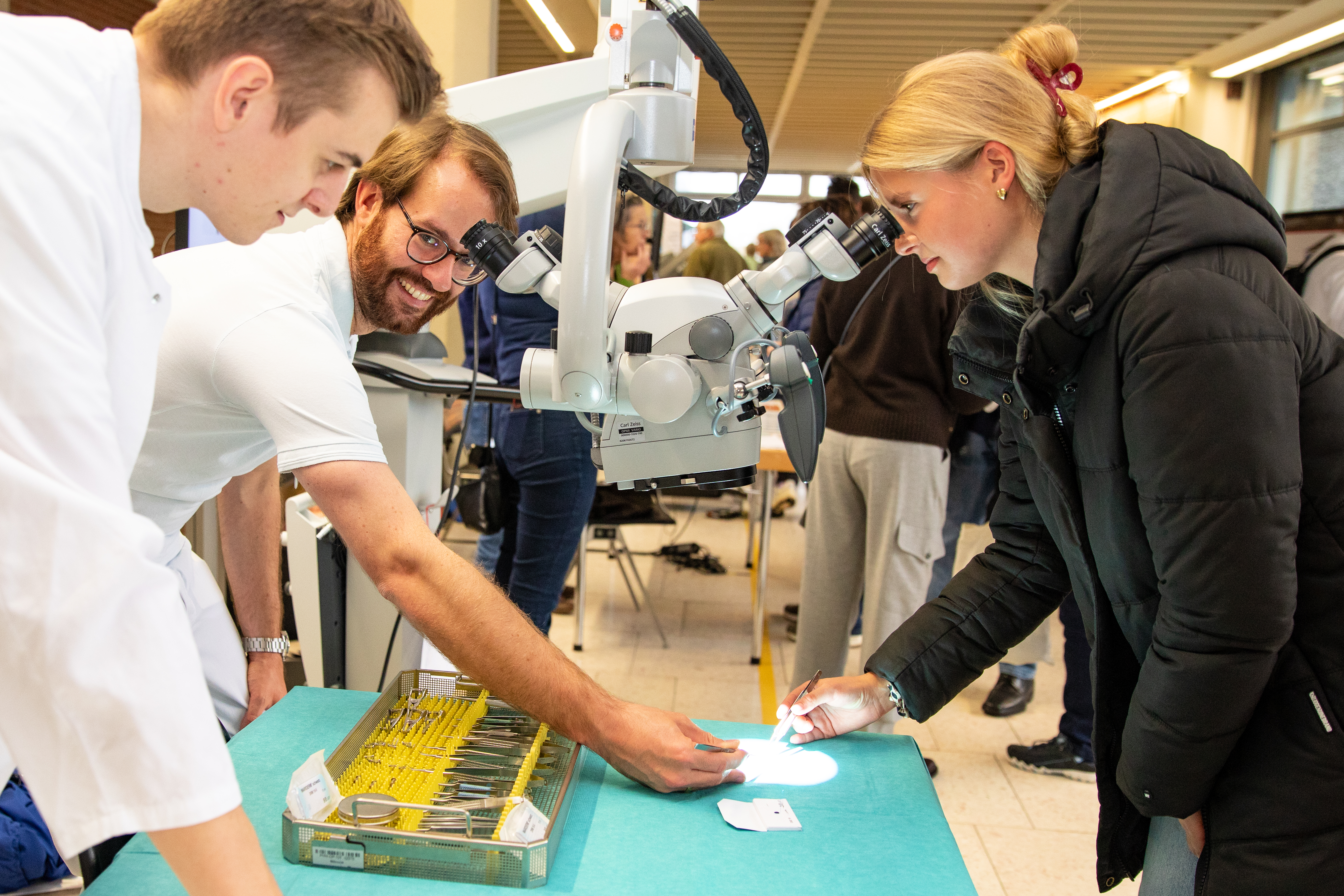 Eine junge Frau schaut durch ein Mikroskop. 