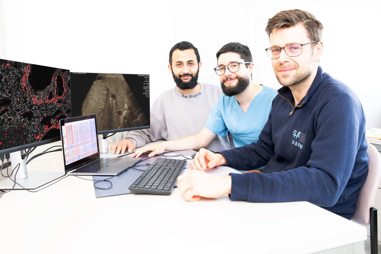 Ahmed Alaswad, Alejandro Campos-Murguia und Dr. Bastian Engel sitzen vor Monitoren mit mikroskopischen Abbildungen.