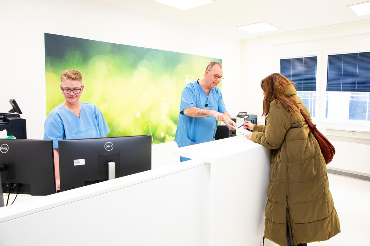 Eine Krebspatientin steht an der Anmeldung mit Holger Brügmann, dem pflegerischen Leiter der OIA.