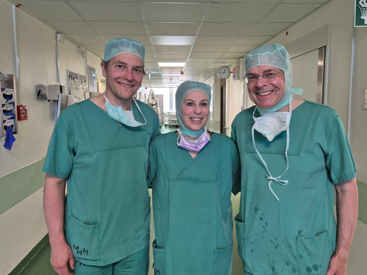Ein Chirurgie-Team, bestehend aus zwei Männern und einer Frau. 