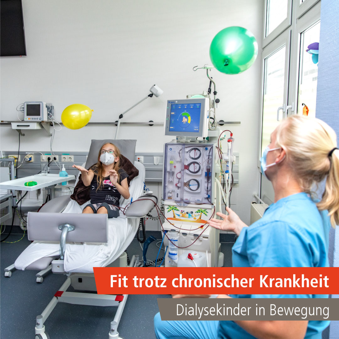 Die Patientin Jasmine sitzt im Bett und streckt sich nach Luftballons aus, Therapeutin Johanna Boyen schaut zu.