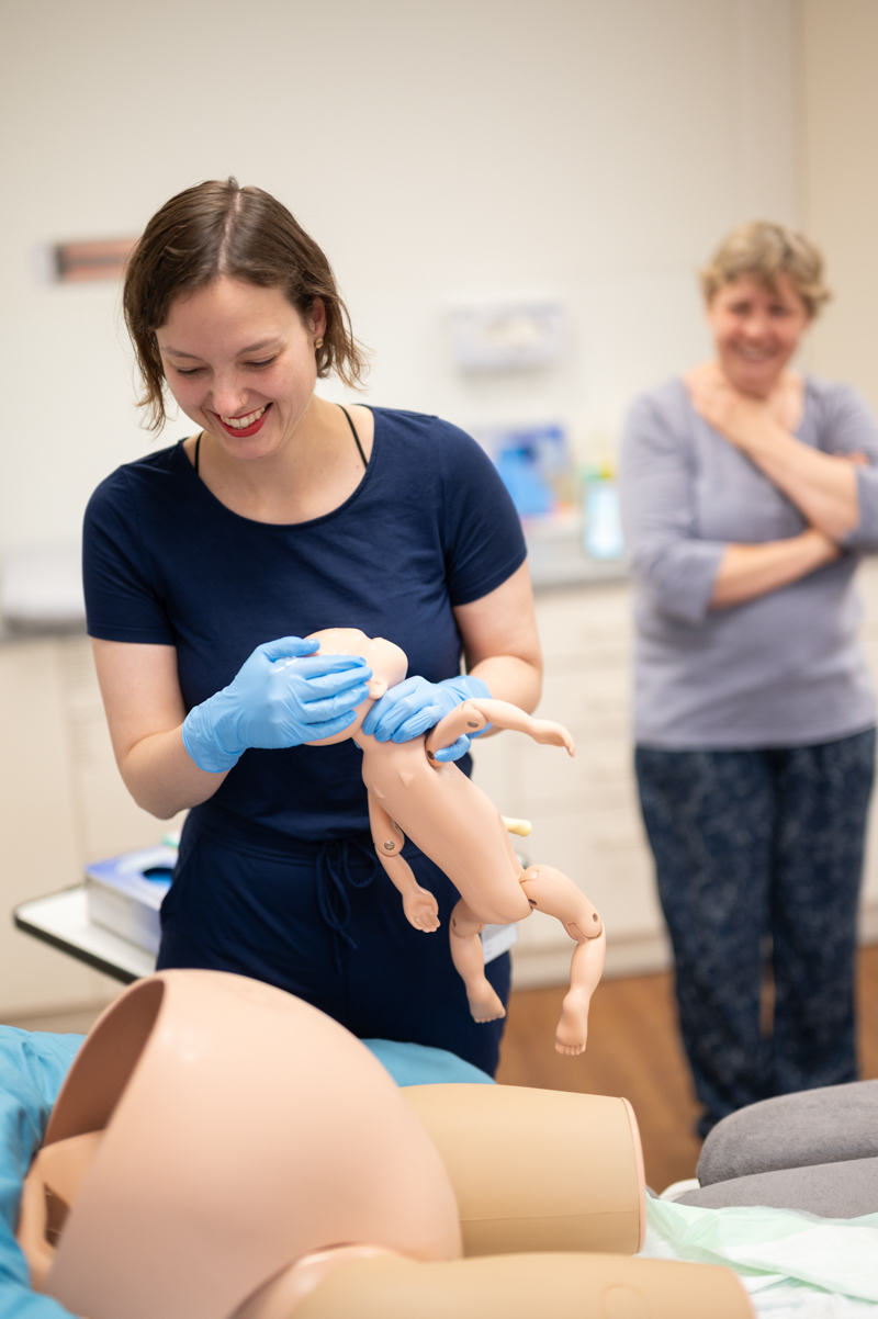 Eine Frau hält eine Babypuppe