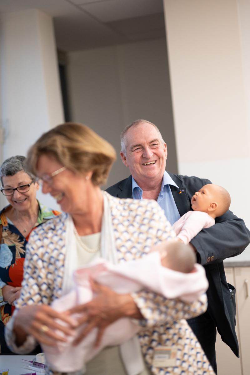 ein Mann und eine Frau halten jeweils eine Babypuppe im Arm