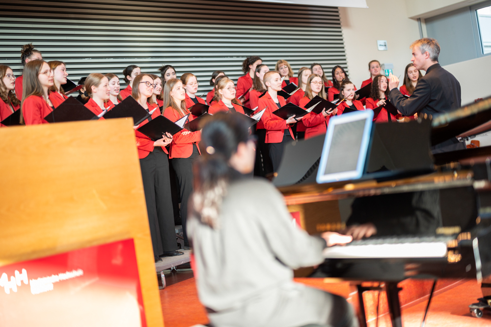 Im Vordergrund sitzt die Pianistin am Klavier.