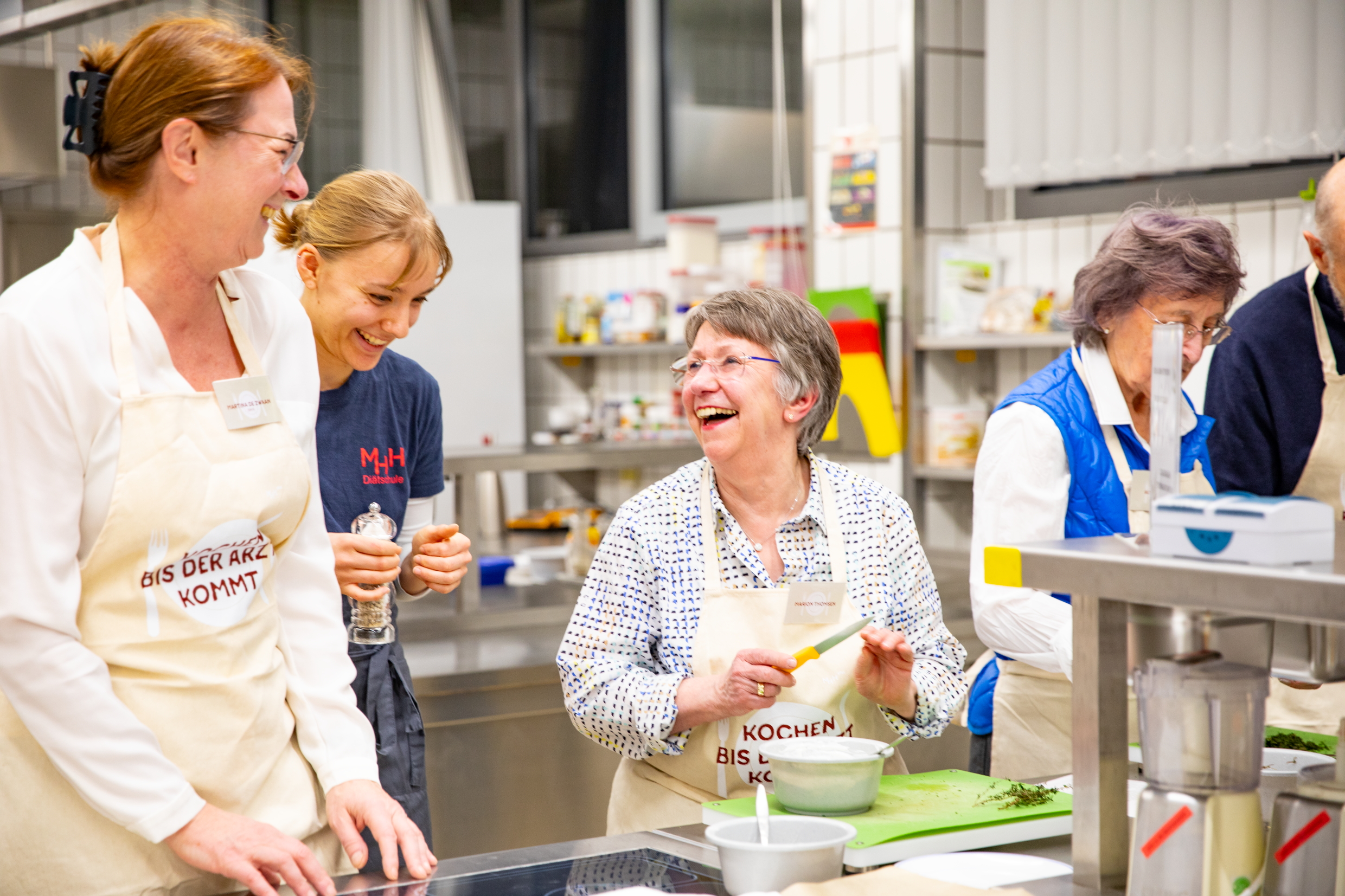 Die beiden Frauen lachen sich beim Kochen an.