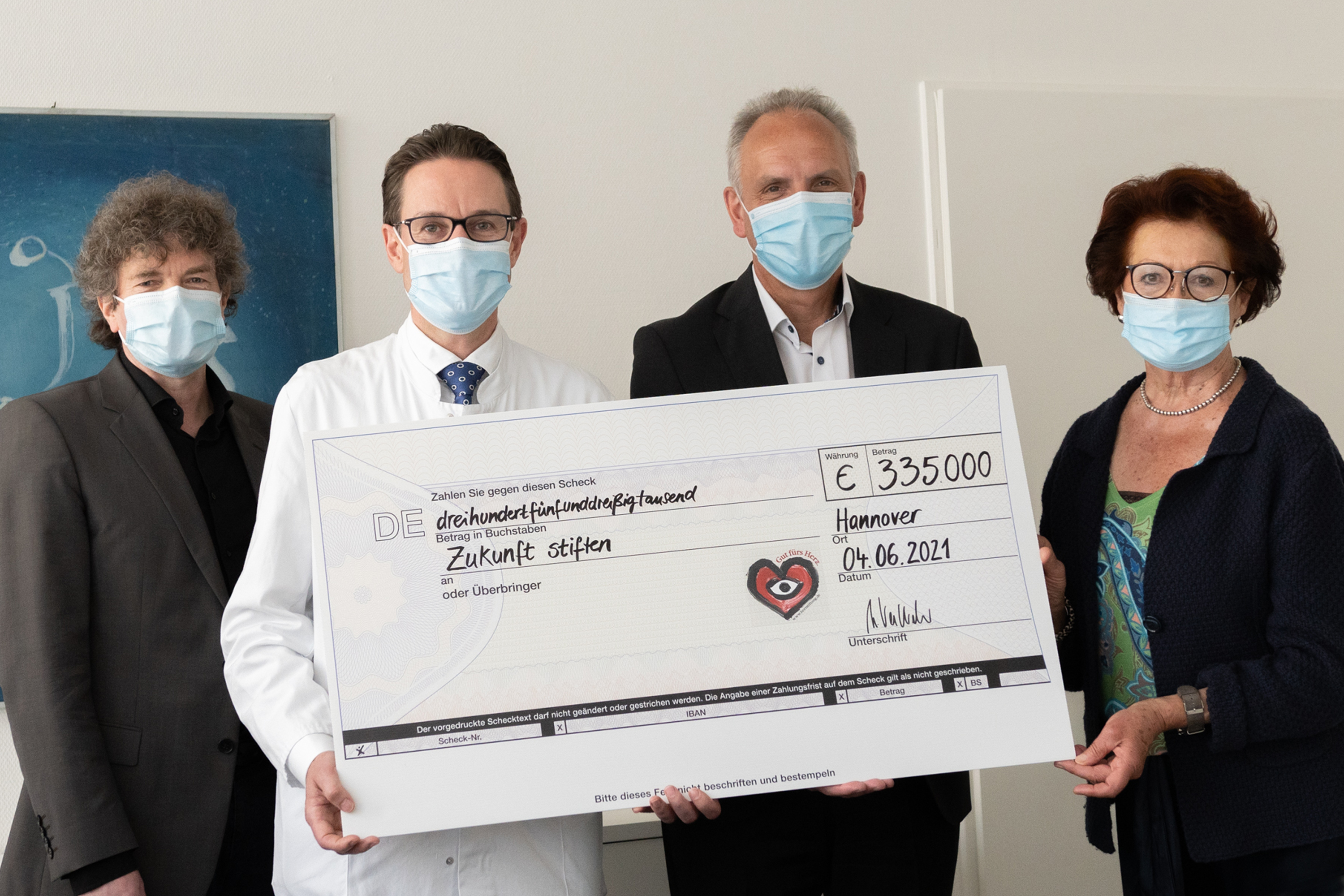 Dr. Eckhard Schenke, Professor Johann Bauersachs sowie Martin Vestweber und Gisela Neubauer von der Deutschen Herzstiftung halten gemeinsam einen Spendenscheck hoch. 