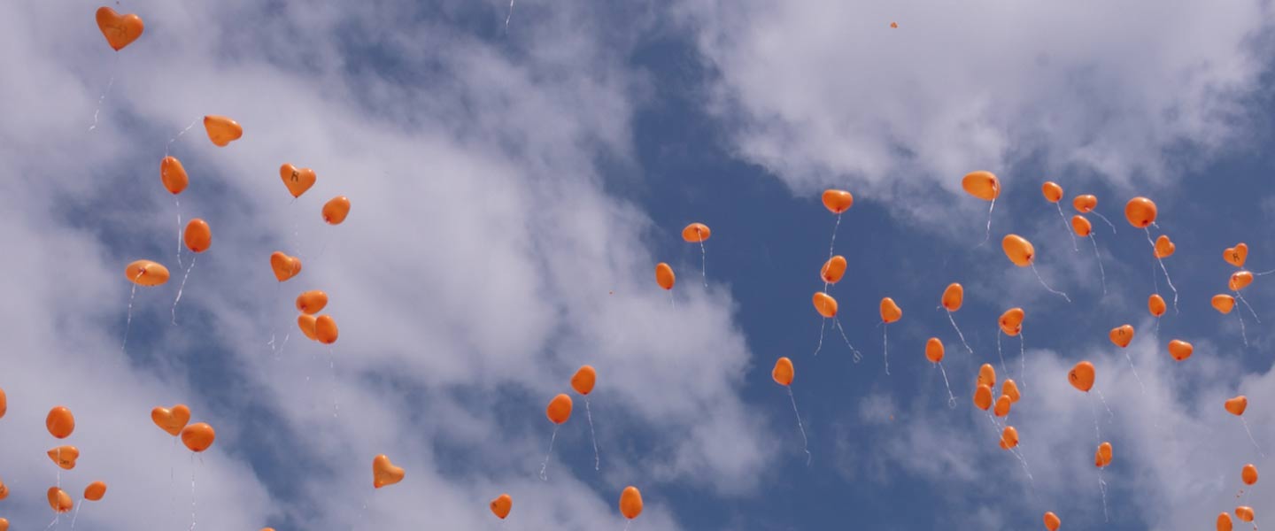Orangefarbene Luftballons im Himmel. Copyright: Stiftung Über Leben – Initiative Organspende