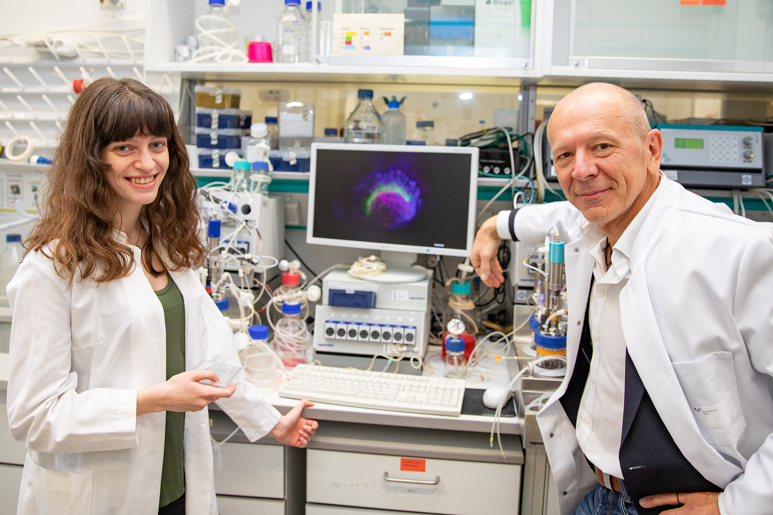 Dr. Lika Drakhlis und Dr. Robert Zweigerdt mit Bioreaktoren und einer speziellen Zellkulturschale, die als Plattform für die Anzucht der hPSC-Aggregate dient. Copyright: Karin Kaiser / MHH. 