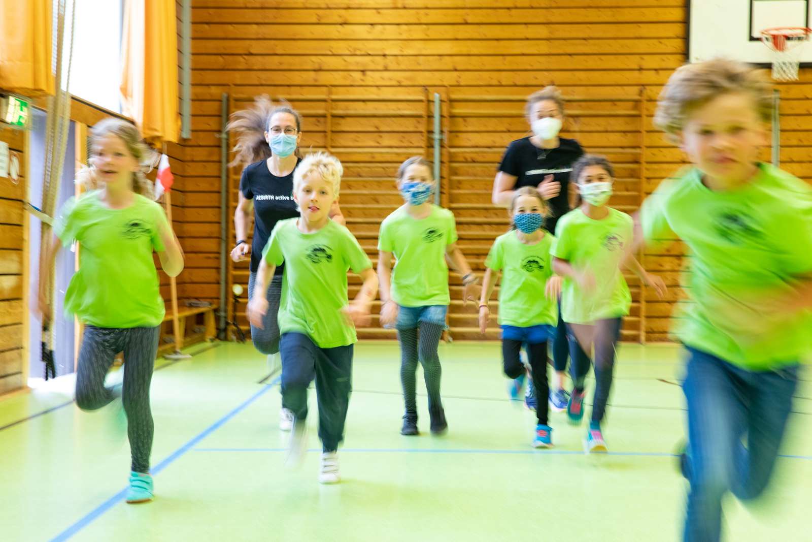 Schüler_innen und zwei Trainer sprinten in einer Turnhalle. Copyright: Karin Kaiser/MHH