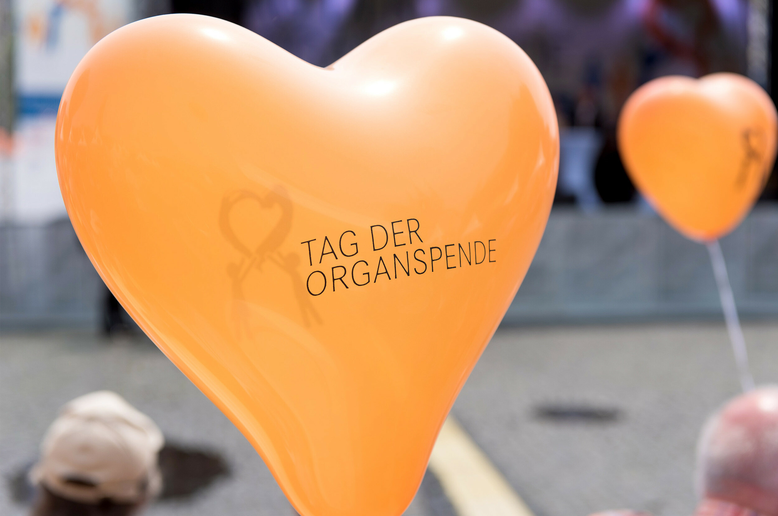 Orangefarbene Herzballons mit Logo des Tages der Organspende; Copyright: BZgA / Christian Schneider-Bröcker
