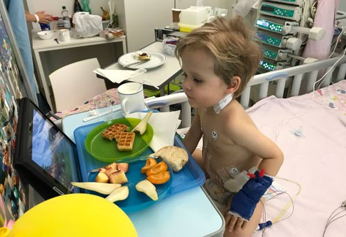 Noah nach der erfolgreichen Lebertransplantation. Er sitzt im Patientenbett und schaut sich einen Film an. / Copyright: Oliver Aberle