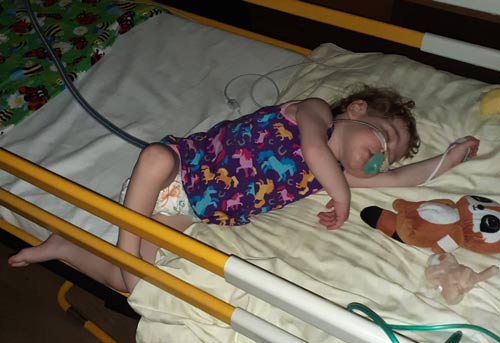 Sofie schläft im Patientenbett. Sie trägt eine Sauerstoffbrille. Copyright: privat